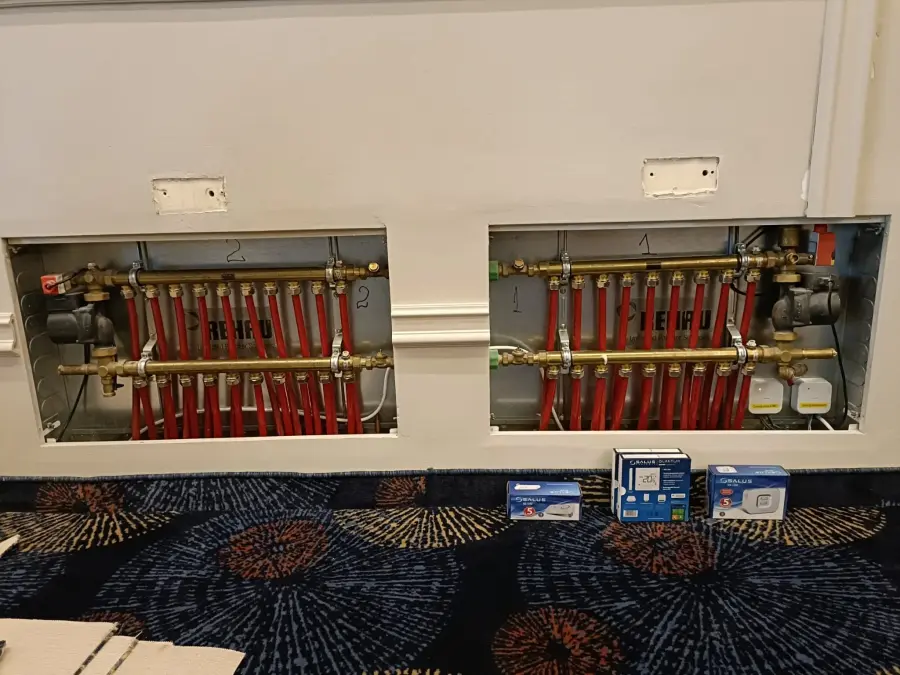 Două colectoare de încălzire în pardoseală montate încastrat în perete, cu toate circuitele racordate