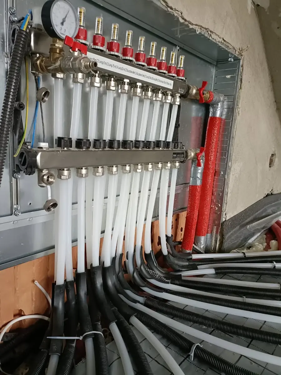 Colector de încălzire în pardoseală cu debitmetre pe fiecare circuit, în timpul racordării tuburilor